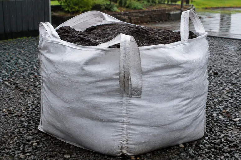 Big bag de terreau stocké en extérieur sous la pluie avec un volume important
