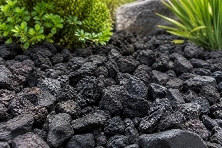 Gros plan sur les pierres concassées d'une pouzzolane noir de gros calibre dans un jardin